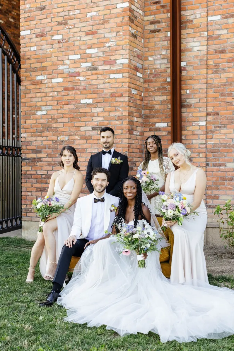 Newlyweds and their wedding party with colourful bouquets