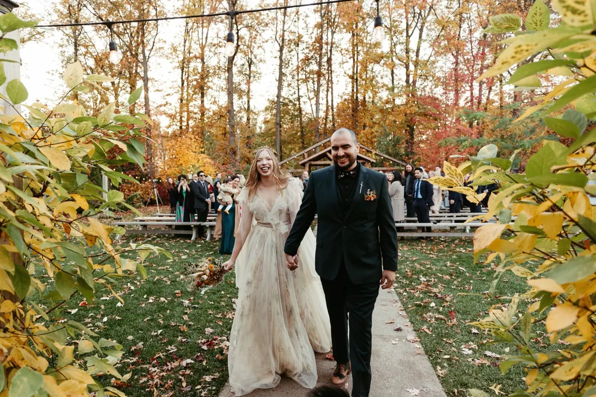 The same autumn wedding couple walking together after their ceremony